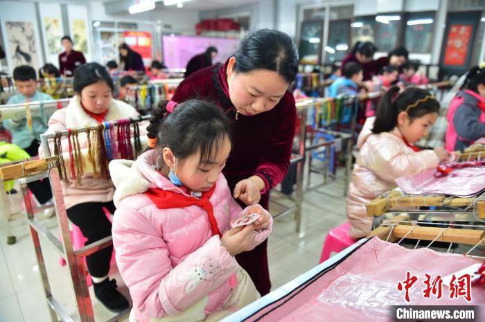 江西省級非遺豫章繡傳承人手把手指導(dǎo)小學(xué)生繡制2022年北京冬奧會(huì)吉祥物“冰墩墩”形象。　喻云亮 攝