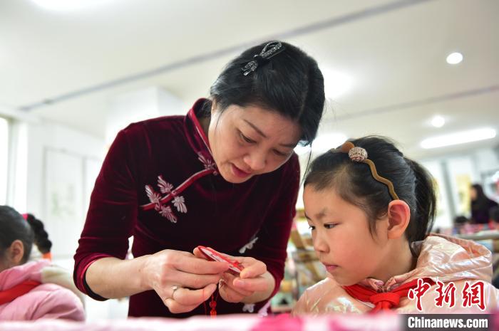 江西省級非遺豫章繡傳承人手把手指導(dǎo)小學(xué)生繡制2022年北京冬奧會(huì)吉祥物“冰墩墩”形象。　喻云亮 攝