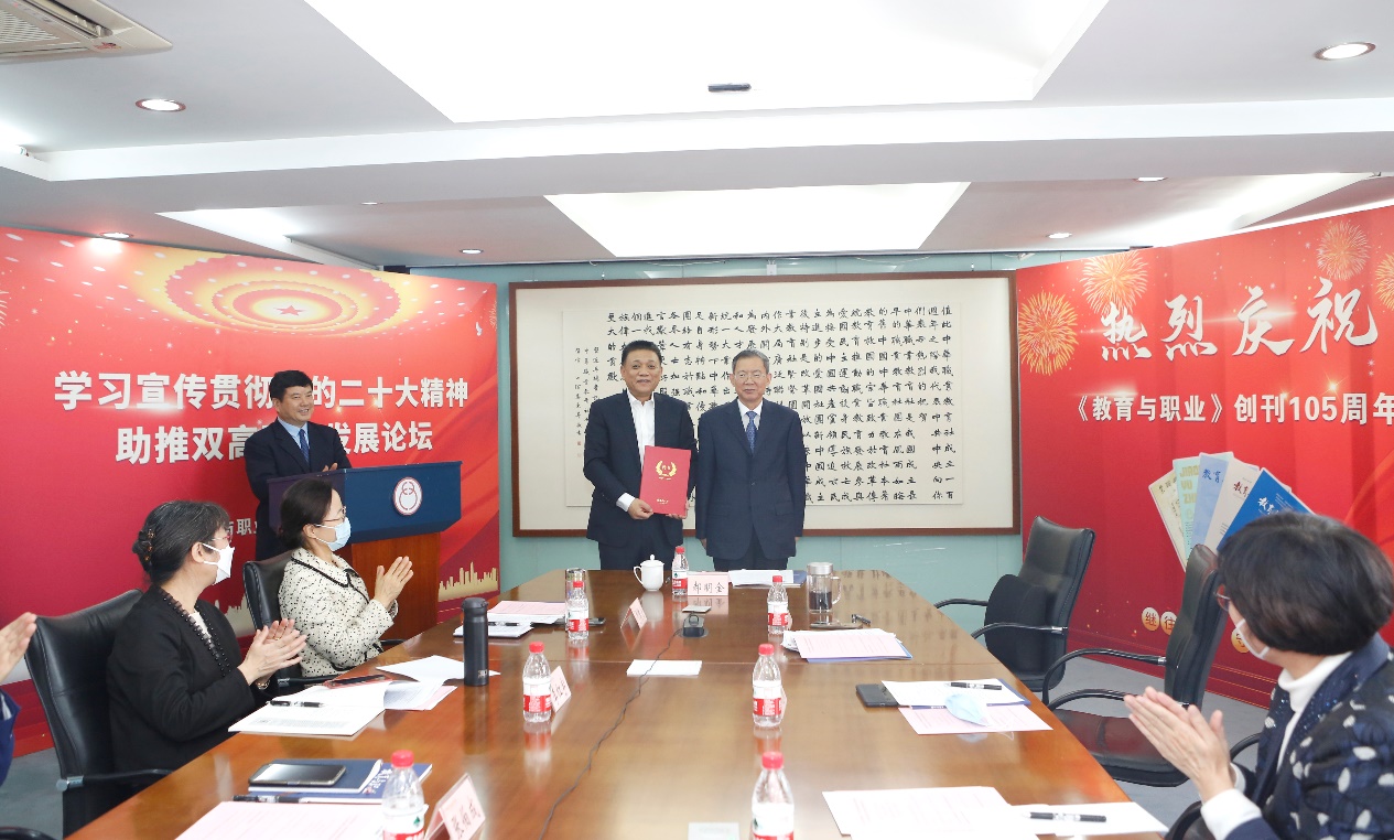 郝明金為《教育與職業(yè)》雜志編委代表陳曉明頒發(fā)聘書。中華職教社供圖