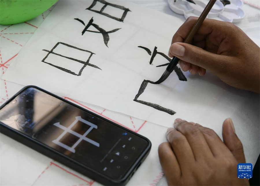 4月18日，肯尼亞學(xué)生在內(nèi)羅畢大學(xué)孔子學(xué)院舉辦的活動上寫毛筆字?？夏醽唭?nèi)羅畢大學(xué)孔子學(xué)院18日舉辦“中文，增進文明對話”主題活動，慶祝即將到來的第14個聯(lián)合國中文日?？夏醽唽W(xué)生參與互動，進行書法、剪紙、唱中文歌等活動。新華社記者 韓旭 攝