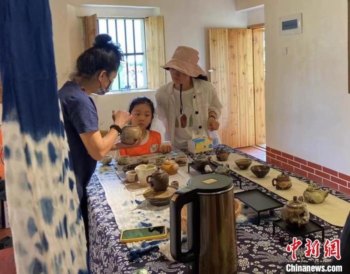 圖為：游客正在咨詢臺(tái)灣柴燒作品?！∪~秋云 攝