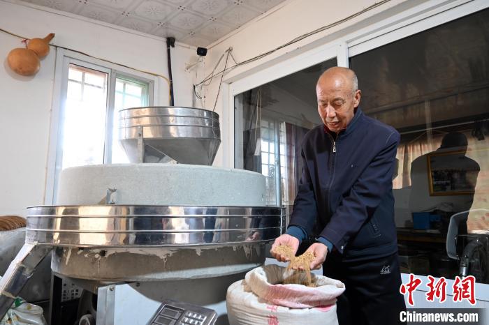 李家莊村民谷文朝重拾父輩的手藝，做起石磨面粉的營生?！〉杂鸺?攝