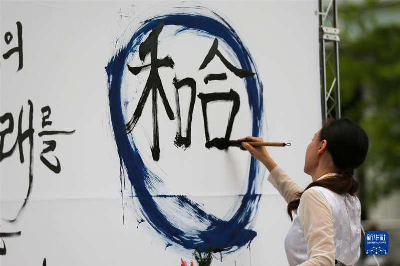 5月30日，在韓國首爾舉辦的“中日韓合作之日”慶?；顒又?，表演者進(jìn)行中日韓精神——2023年度漢字“和合”書法表演。新華社記者 王益亮 攝