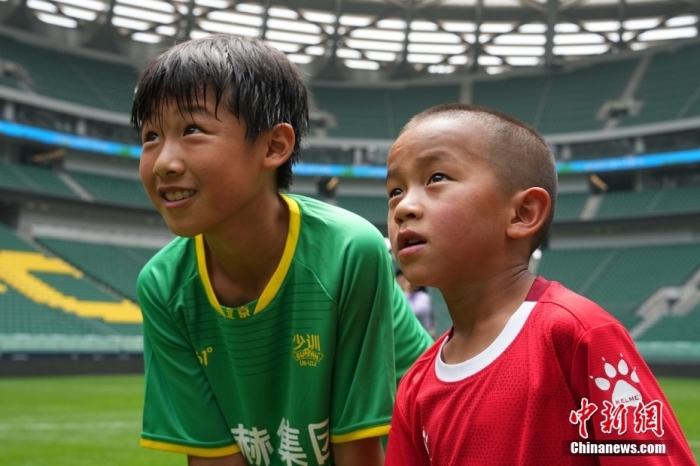 圖為北京國安小球員陳小北和7歲的俄金仁增在一起觀看場內(nèi)播放的紀錄片。<a target='_blank' href='/' _fcksavedurl='/'><p  align=