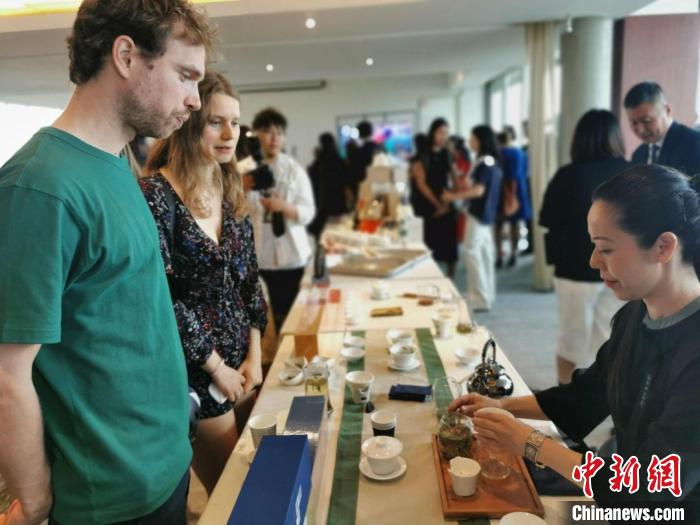 現(xiàn)場觀眾觀看中國展臺(tái)茶藝表演、了解茶文化。　靖樹 攝