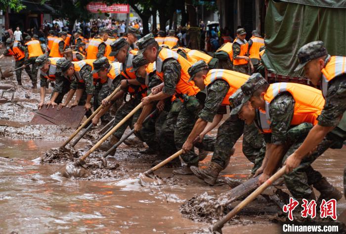 7月4日，萬(wàn)州區(qū)五橋街道，武警官兵清理街道上的淤泥。　冉孟軍 攝