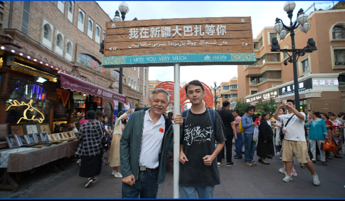 潘維廉和維吾爾族青年伊木蘭“打卡”大巴扎。主辦方供圖