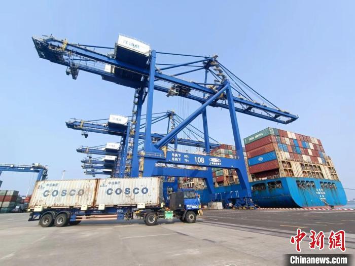圖為海南洋浦國際集裝箱碼頭，卡車將集裝箱從后方堆場運(yùn)往碼頭裝卸區(qū)?！?jiān)潞?攝