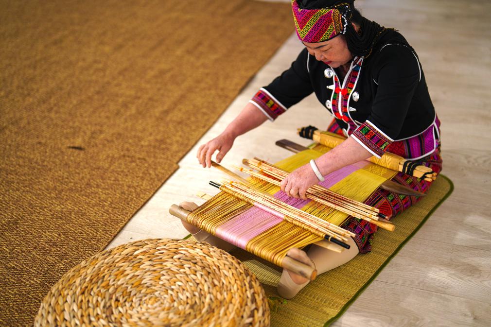 4月17日，黎族傳統(tǒng)紡染織繡技藝國家級代表性傳承人劉香蘭在2023年意大利米蘭設計周上展示黎錦織造技藝。新華社發(fā)
