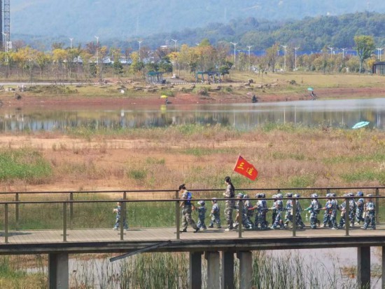 　　10月24日，秋游的幼兒園小朋友在老師帶領(lǐng)下走在清水塘公園里的木橋上。本報(bào)記者 常雯宜攝