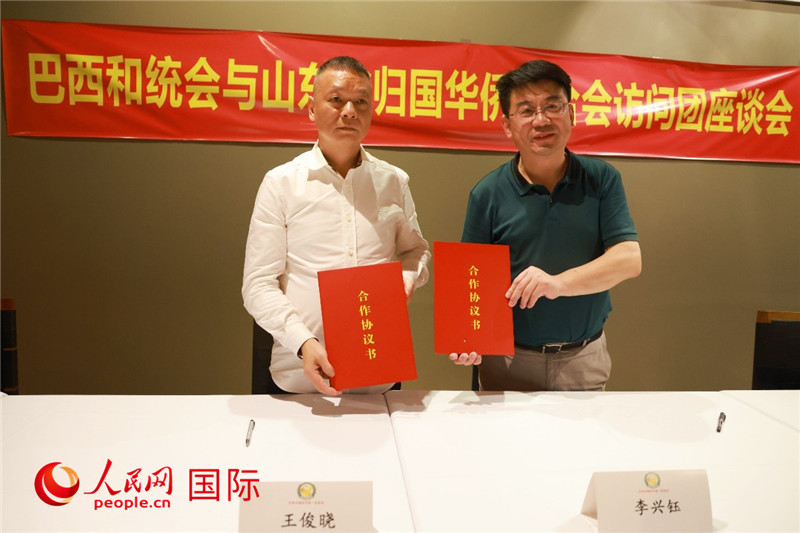 中國僑聯(lián)副主席、山東省僑聯(lián)主席李興鈺（右）與巴西和統(tǒng)會會長王俊曉簽署合作協(xié)議書。人民網(wǎng)記者 陳海琪攝