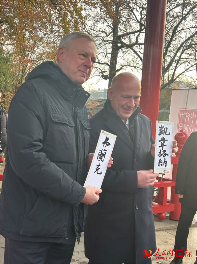柏林市長韋格納（右）、動物園監(jiān)事會主席布魯克曼（左）手持中國文化中心工作人員現(xiàn)場手書的中文名字。人民網(wǎng)記者 徐馨攝