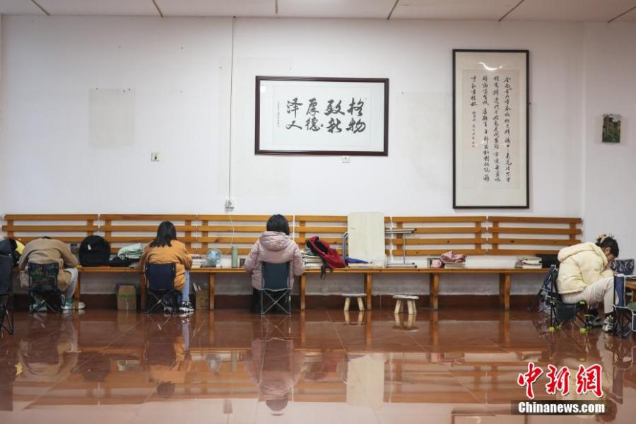 資料圖：幾位考研學(xué)生在南昌大學(xué)教學(xué)樓的公共空間復(fù)習(xí)備考。劉力鑫 攝