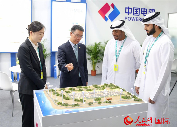 訪客在中國電建展臺參觀風(fēng)電項目沙盤。人民網(wǎng) 塔里克·易卜拉欣攝