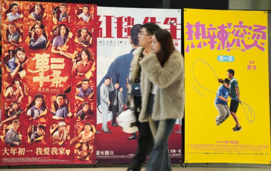 這是2月17日，在沈陽(yáng)一家影院，觀眾從海報(bào)前經(jīng)過(guò)。新華社記者李鋼攝