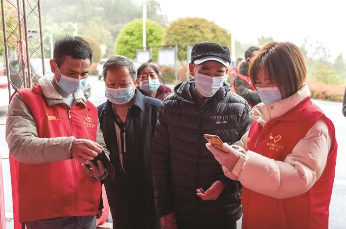 長沙縣黨員志愿者正在幫助參與核酸檢測的群眾掃描“場所碼”。劉思源 攝