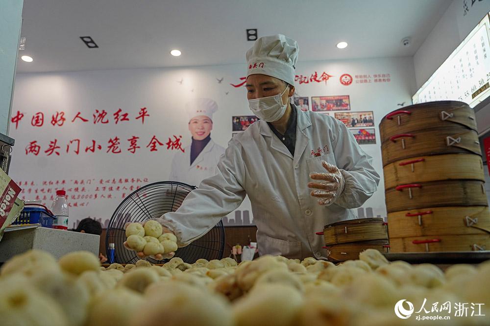 3月31日，在浙江省嵊州市甘霖鎮(zhèn)，嵊州小吃從業(yè)者沈紅平把蒸熟的小籠包晾涼，打包冷藏售賣。人民網(wǎng) 章勇濤攝