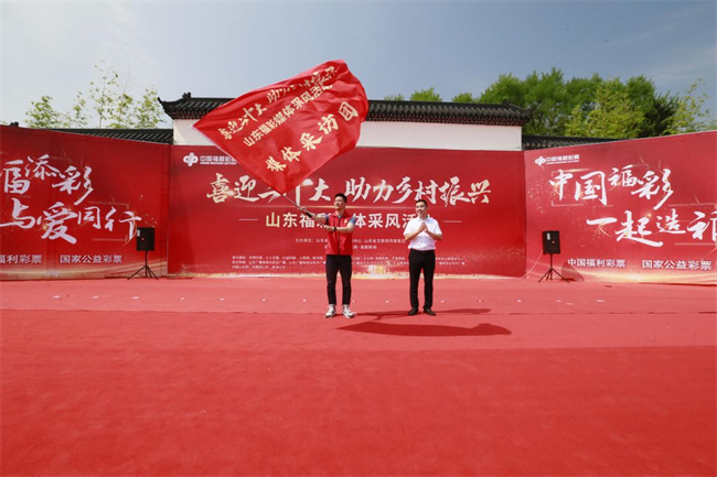 為媒體采風(fēng)團(tuán)授旗。 山東省福彩供圖