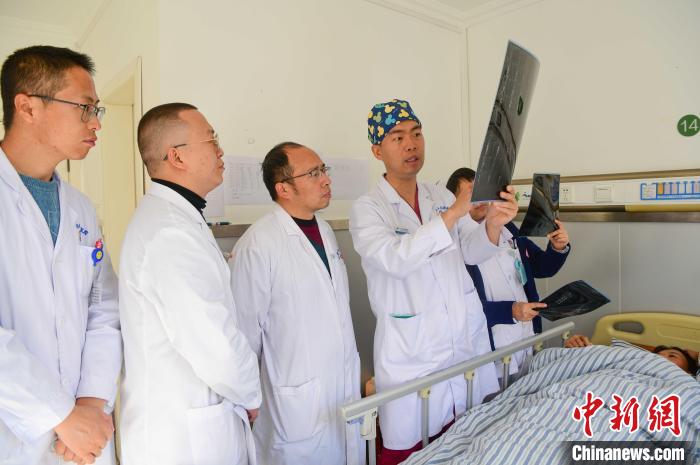 圖為醫(yī)療援藏專家何蔚(站右二)與馮敬云(左二)、廖濤(左三)等人討論患者病情。(資料圖) 貢嘎來(lái)松 攝
