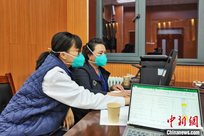 8月9日，楊蘇喬(左)在拉薩方艙醫(yī)院指揮部讀取艙內(nèi)患者胸部CT?！∈茉L者供圖