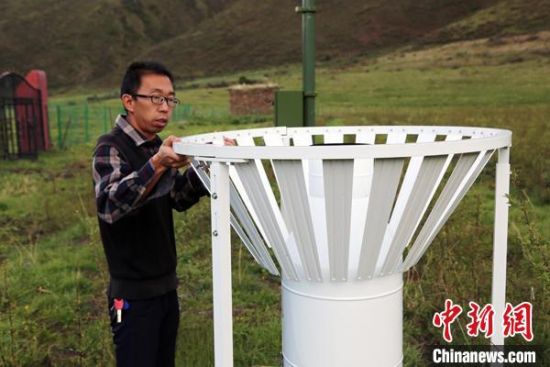 圖為班瑪縣氣象局工作人員在維護(hù)藏雪茶基地氣候站。青海省氣象局供圖