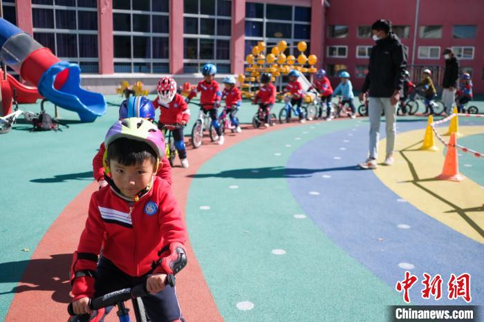圖為拉薩市實(shí)驗(yàn)幼兒園孩子們?cè)诮叹毜闹笇?dǎo)下練習(xí)滑步車。　何蓬磊 攝