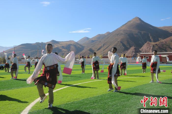 圖為青海師范大學(xué)附屬玉樹實(shí)驗(yàn)學(xué)校學(xué)生在綠茵場跳起囊謙古舞—卓根瑪?！〕逃?攝