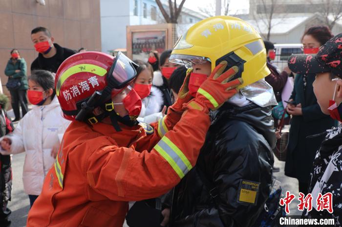 圖為小朋友體驗(yàn)試穿消防滅火防護(hù)服。　楊龍建 攝