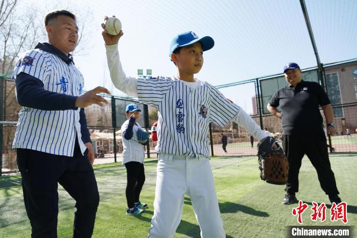 圖為教練指導(dǎo)小棒球手?jǐn)S球技術(shù)?！●R銘言 攝