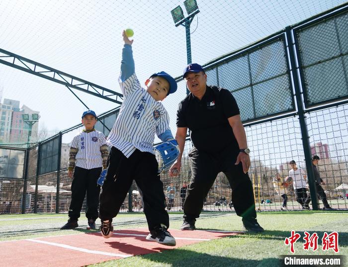圖為來自臺灣的棒球教練劉興鴻(右)指導(dǎo)小棒球手?jǐn)S球技術(shù)?！●R銘言 攝