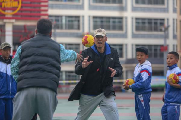 在高原上教孩子們打手球，“慢慢兒來，甭著急！”