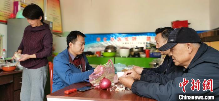 圖為扶貧路上“臨時一家人”準(zhǔn)備午餐?！∥航ㄜ?攝