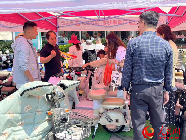 某電動自行車品牌工作人員向消費者介紹以舊換新相關情況。人民網記者 杜燕飛攝