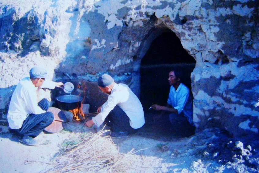 1983年，“六老漢”一代治沙人在“地窩子”生活做飯。新華社發(fā)（八步沙林場(chǎng)供圖）