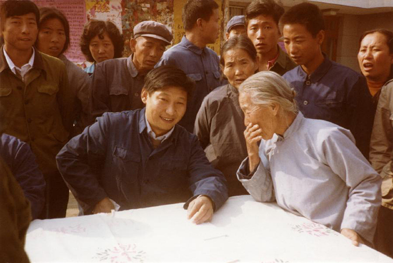 1983年，時(shí)任河北正定縣委書記的習(xí)近平（前排居中），臨時(shí)在大街上擺桌子聽取老百姓意見。