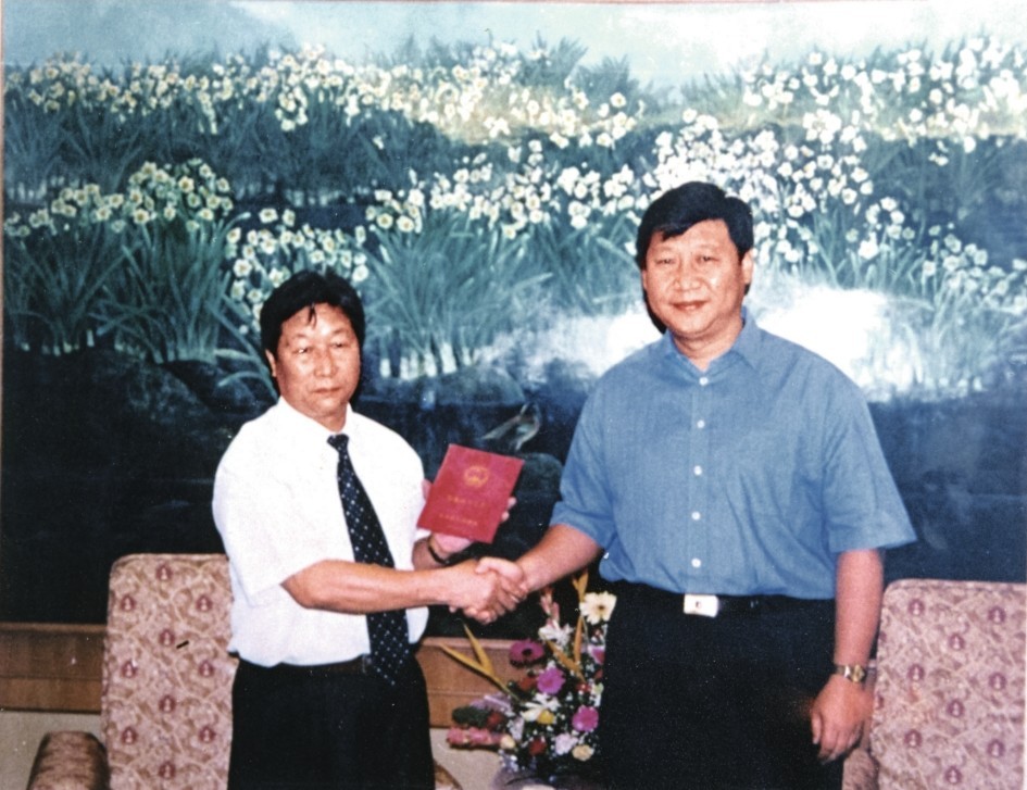 2000年7月，習近平為福建農(nóng)林大學教授林占熺頒發(fā)福建省政府“一等功”榮譽證書。圖源：《習近平在福建》（下）