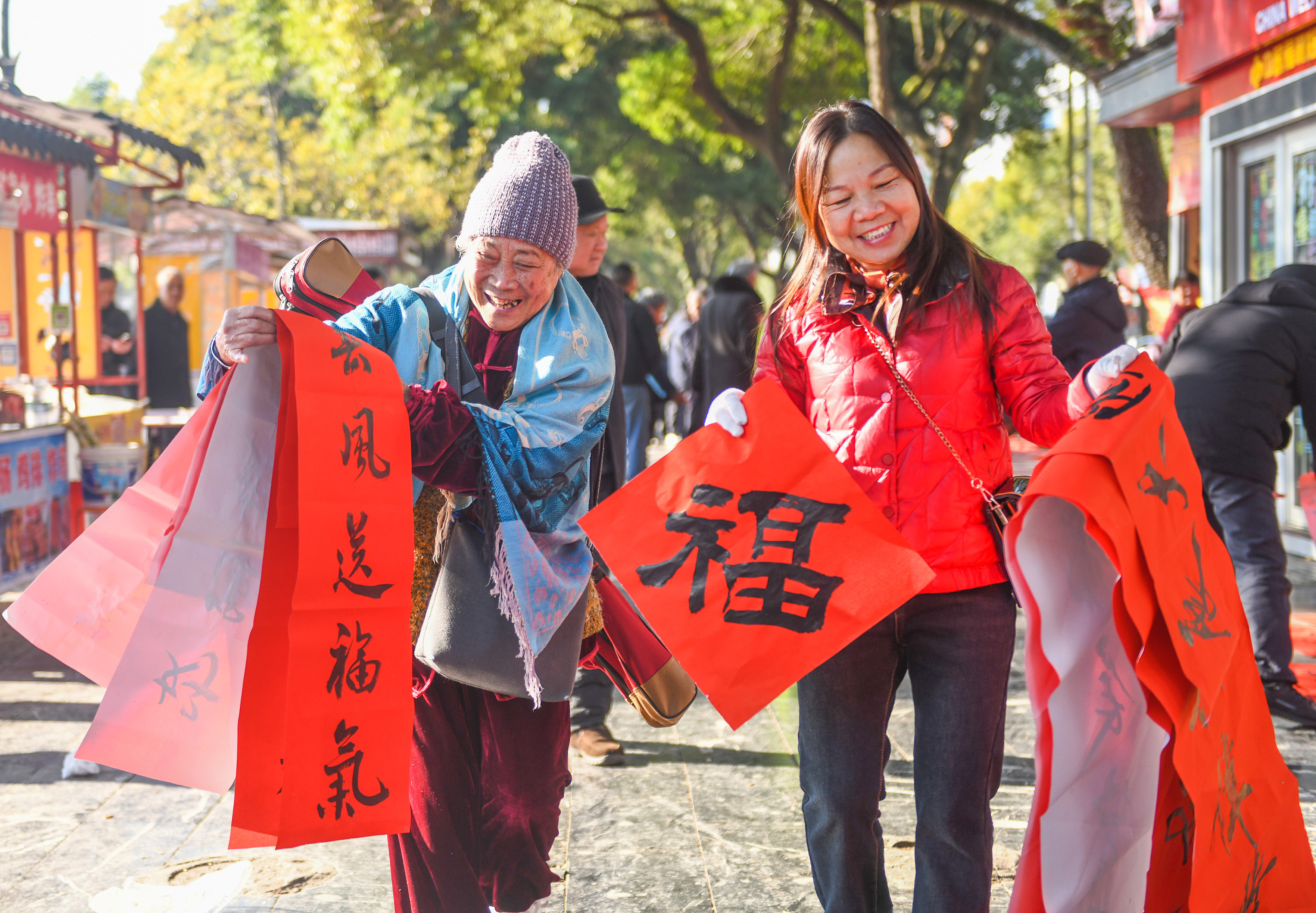 2025年1月13日，在湖南省永州市道縣西洲公園義工崗亭，市民們領到了書法志愿者為大家書寫的春聯(lián)。
