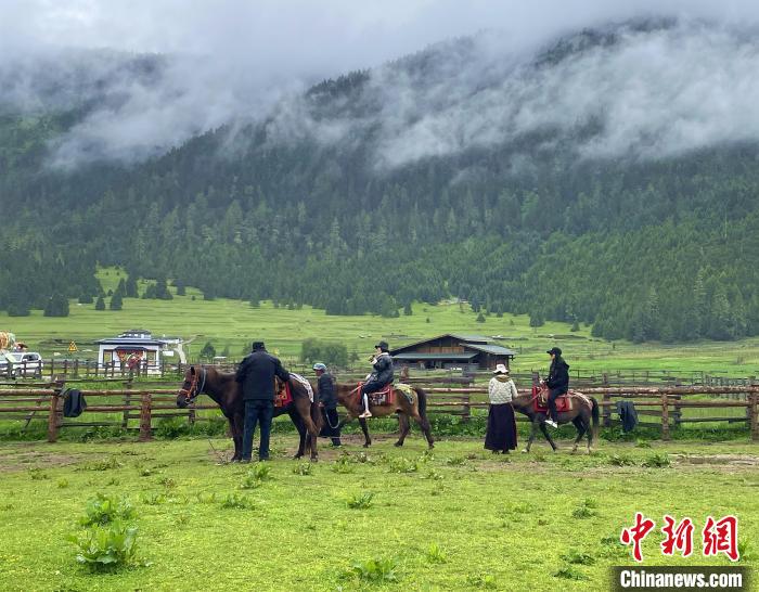 6月10日，游客在魯朗小鎮(zhèn)高山牧場(chǎng)景區(qū)體驗(yàn)騎馬?！∪轿木?攝