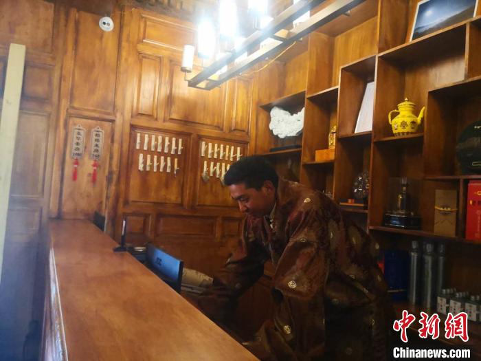 圖為桑杰才讓用電腦處理財(cái)務(wù)?！∈缝o靜 攝