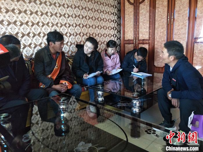 圖為調(diào)查組工作人員正在入戶調(diào)查?！∑钤鲚?攝