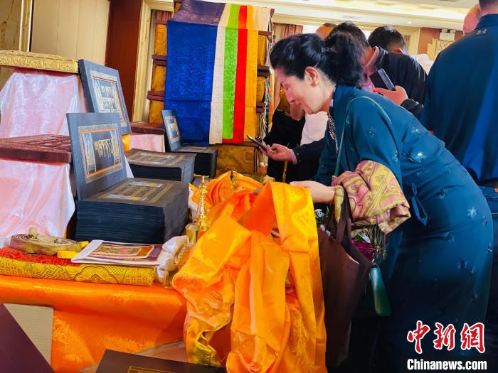 圖為現(xiàn)場藏族民眾向黃金書寫的大藏經(jīng)《甘珠爾》敬獻(xiàn)哈達(dá)?！O睿 攝