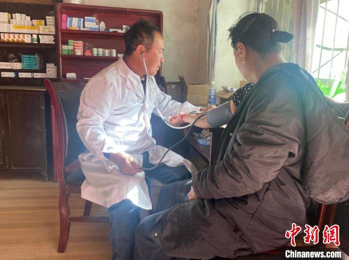 索木滾(左)為村民看病?！∪捞量h委宣傳部供圖