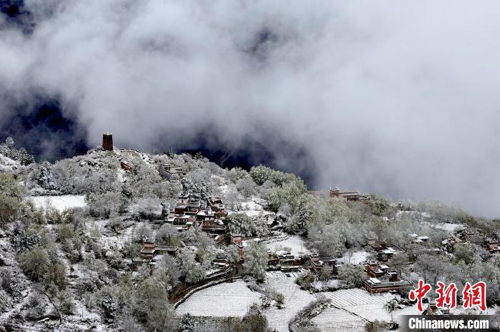 雪后的藏寨和碉樓構(gòu)成美麗的雪景?！〗党鯘衫?攝
