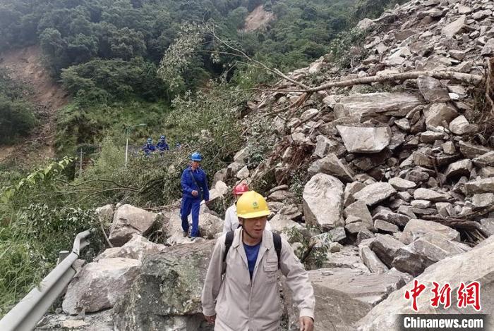 電力搶險(xiǎn)人員徒步通過(guò)垮塌路段。　四川電力供圖