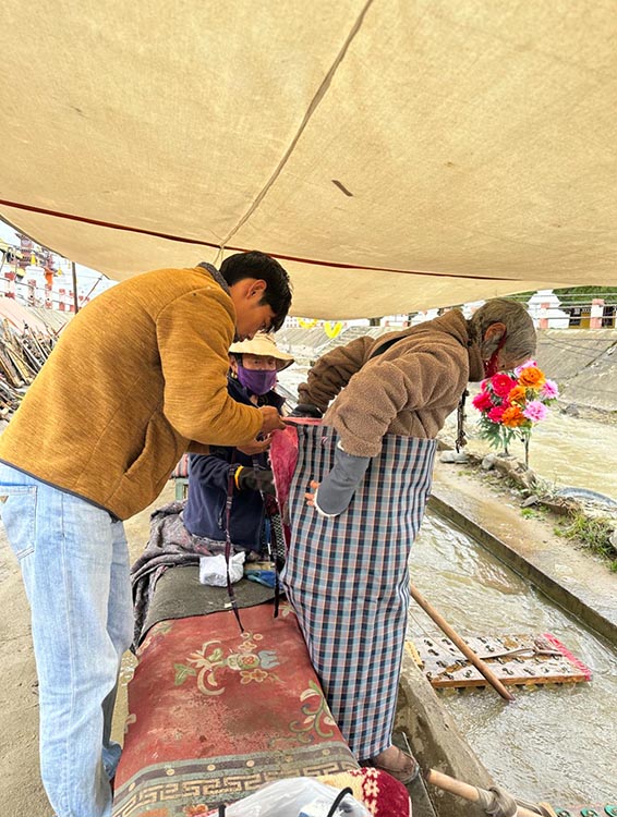 扎西奪爾登為路邊老人送去保暖圍腰。阿壩州文明辦供圖