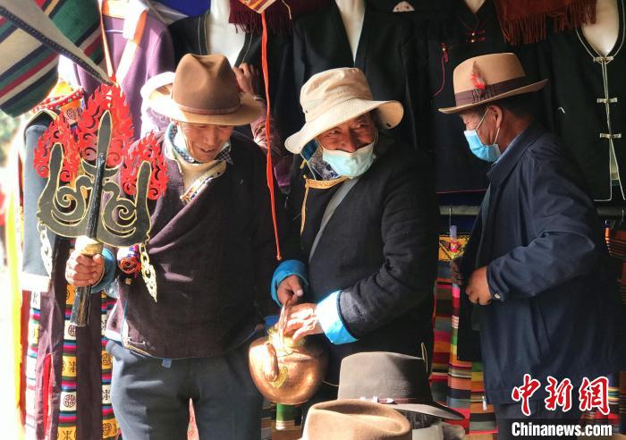 圖為三位藏族老人在集市上聊天交談?！∪轿木?攝