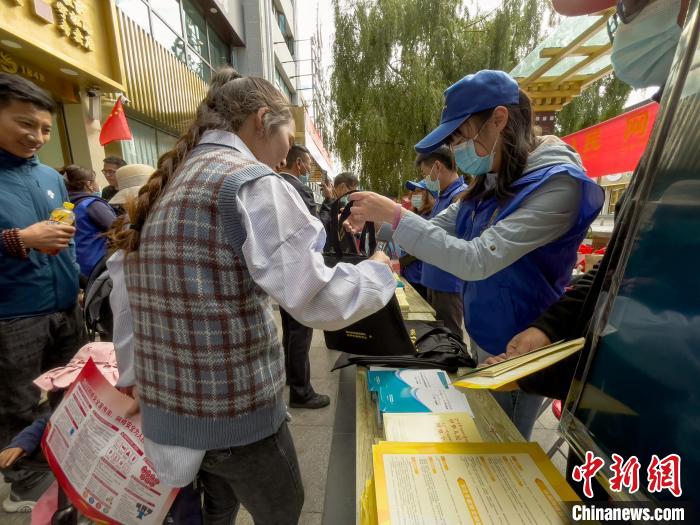 圖為志愿者為市民發(fā)放網(wǎng)絡(luò)安全宣傳手冊。　謝牧 攝