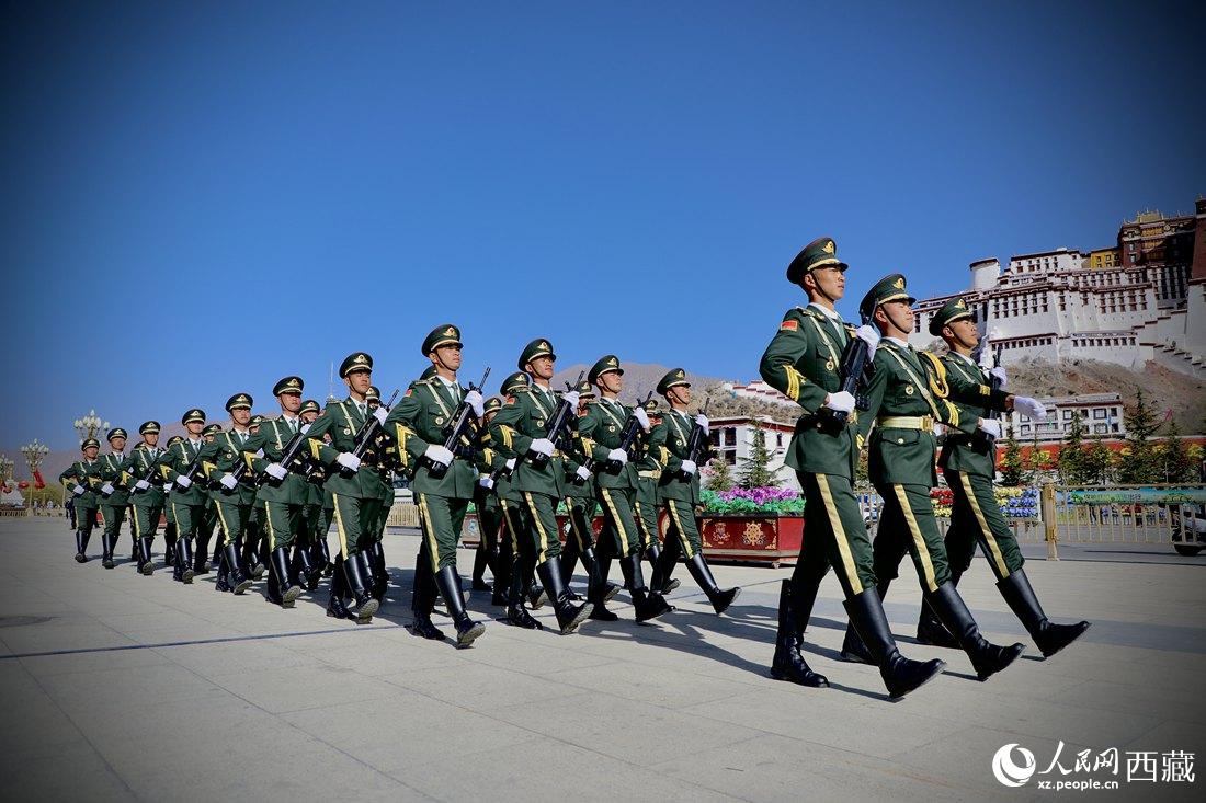 國旗護衛(wèi)隊隊員緊握鋼槍，踏著威武雄壯的步伐，走向國旗臺。人民網(wǎng) 次仁羅布攝