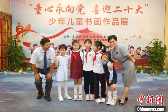 圖為與會嘉賓與入選畫作的“小作者”們在展覽上合影?！≈袊貙W(xué)研究中心供圖