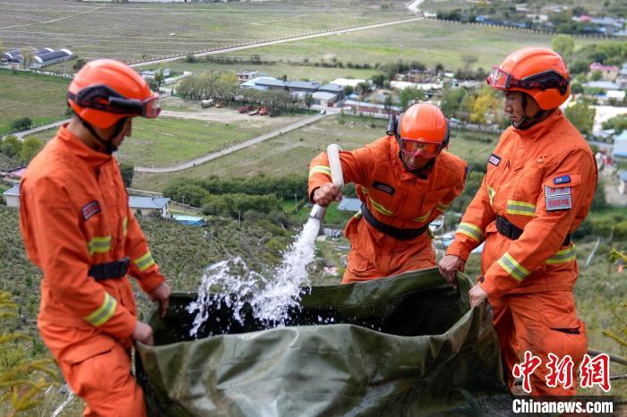 技能大練兵過程中，消防員在陡坡上向蓄水池注水?！±顕鵂c 攝